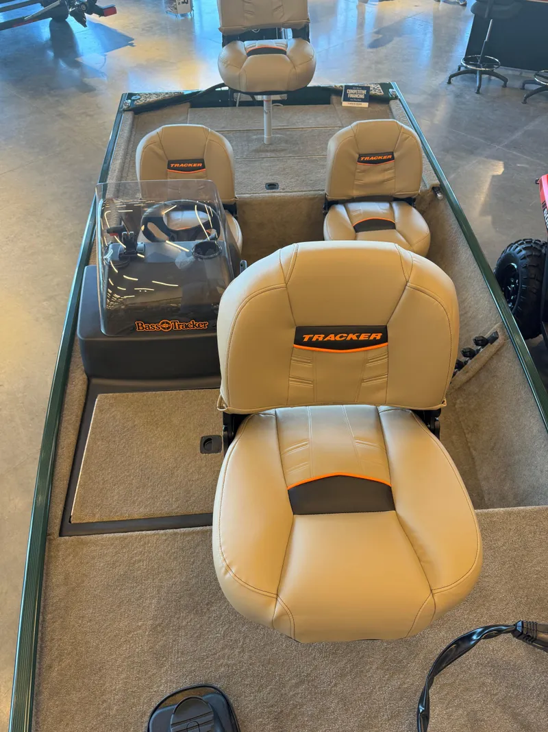 Slide: The Image of 2025 Tracker Bass Tracker Classic Limited boat interior with beige seating and steering console. - 3
