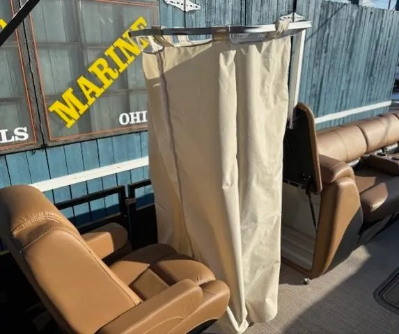 Slide: The Image of 2024 Regency 250 LE3 boat interior with beige seats and privacy curtain. - 15