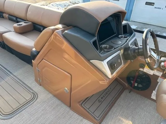 Slide: The Image of 2024 Regency 250 LE3 boat console with steering wheel and seating area. - 18