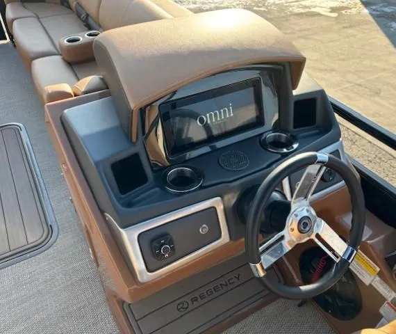 Slide: The Image of 2024 Regency 250 LE3 boat dashboard with steering wheel and touchscreen display. - 19
