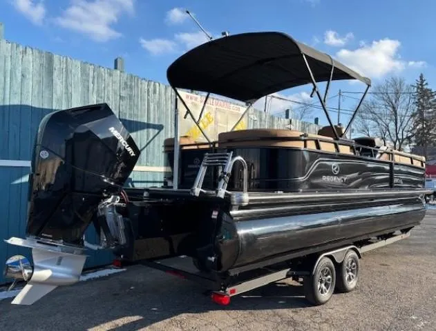 Slide: The Image of 2024 Regency 250 LE3 pontoon boat with black exterior on a trailer. - 4