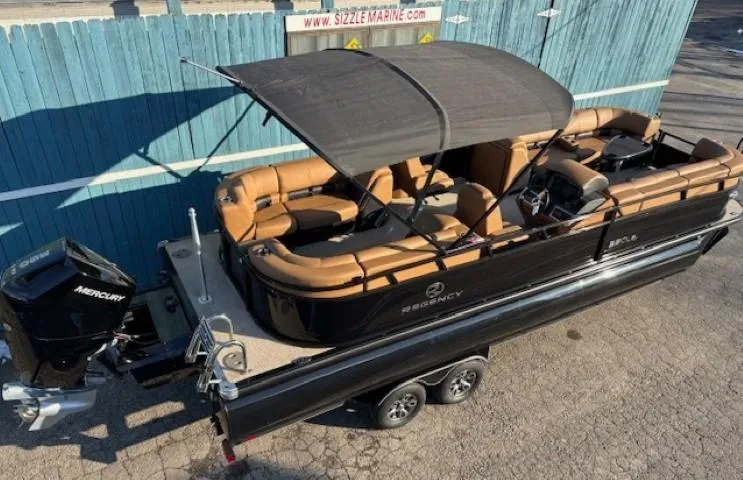 Slide: The Image of 2024 Regency 250 LE3 pontoon boat with canopy and Mercury outboard motor on trailer. - 6