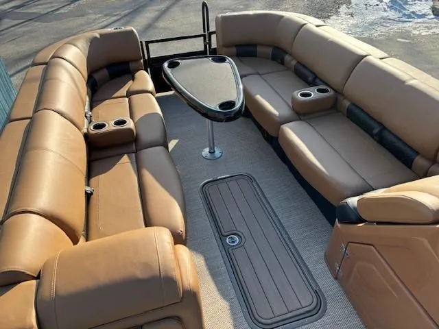 Slide: The Image of 2024 Regency 250 LE3 pontoon boat interior with tan seating and central table. - 8