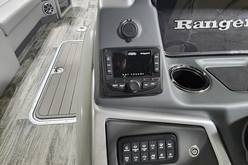 Slide: The Image of Control panel of 2025 Ranger Reata 243C boat with audio system and cup holder. - 10