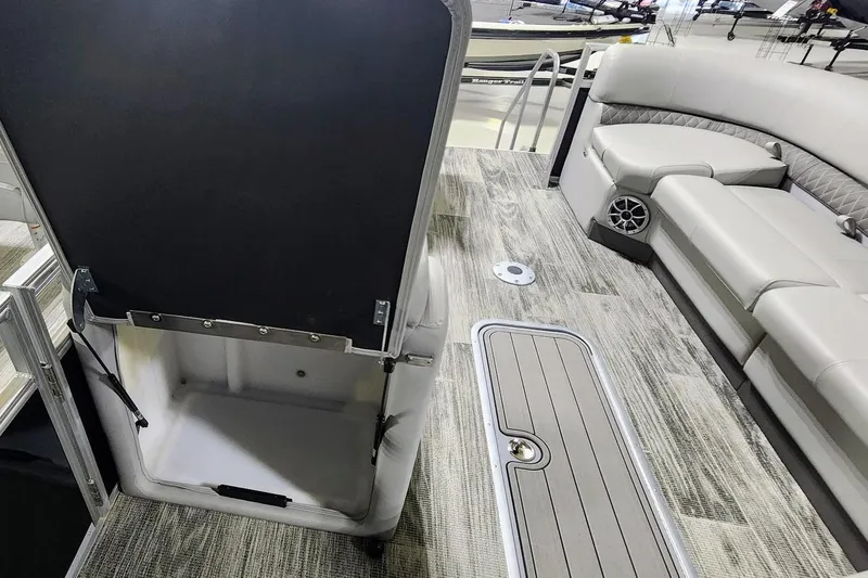 Slide: The Image of 2025 Ranger Reata 243C boat interior with seating, storage, and modern flooring. - 12