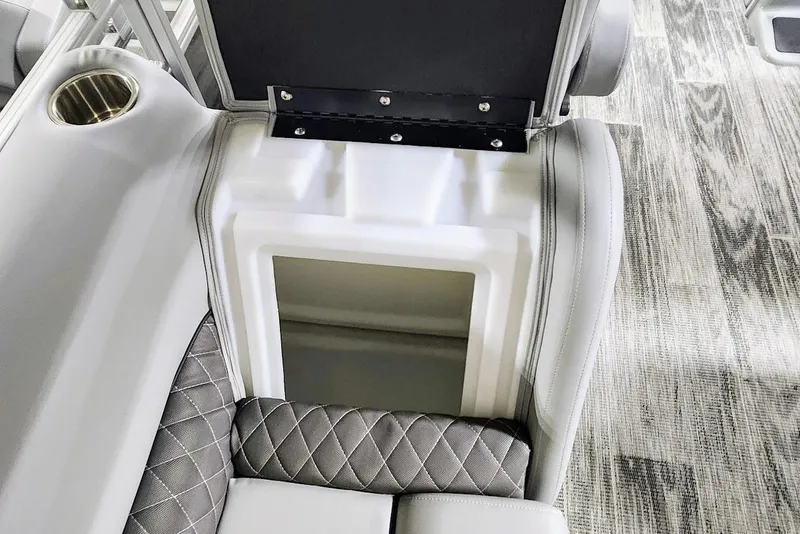 Slide: The Image of 2025 Ranger Reata 243C boat interior with storage compartment and cup holder. - 16