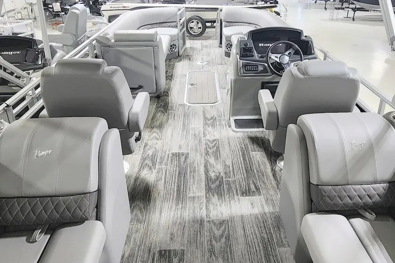 Slide: The Image of 2025 Ranger Reata 243C boat interior with luxurious gray seating and modern dashboard. - 18