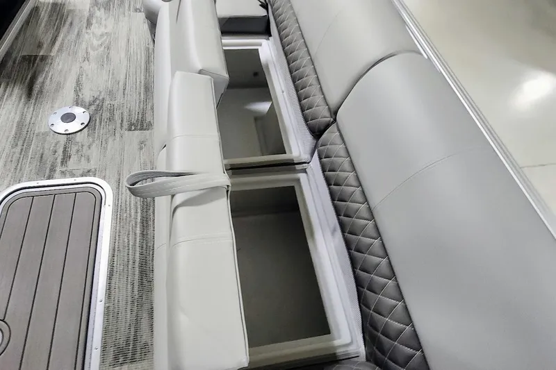Slide: The Image of 2025 Ranger Reata 243C boat interior with gray cushioned seating and storage compartments. - 4