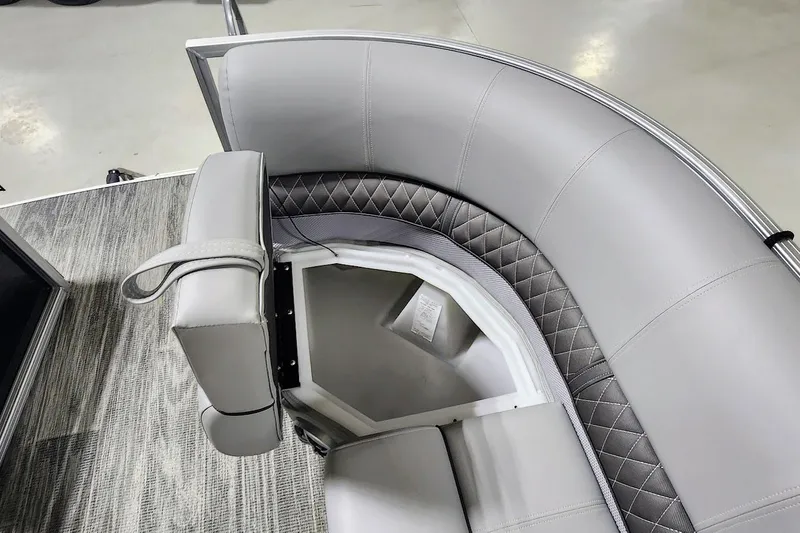 Slide: The Image of 2025 Ranger Reata 243C boat interior with gray cushioned seating and storage compartment. - 5