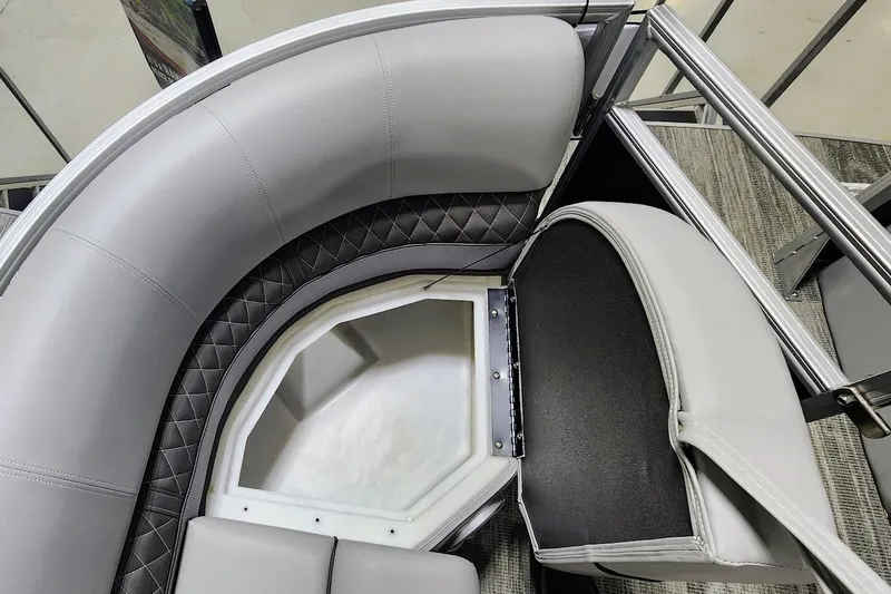 Slide: The Image of 2025 Ranger Reata 243C boat interior with gray cushioned seating and storage compartment. - 6