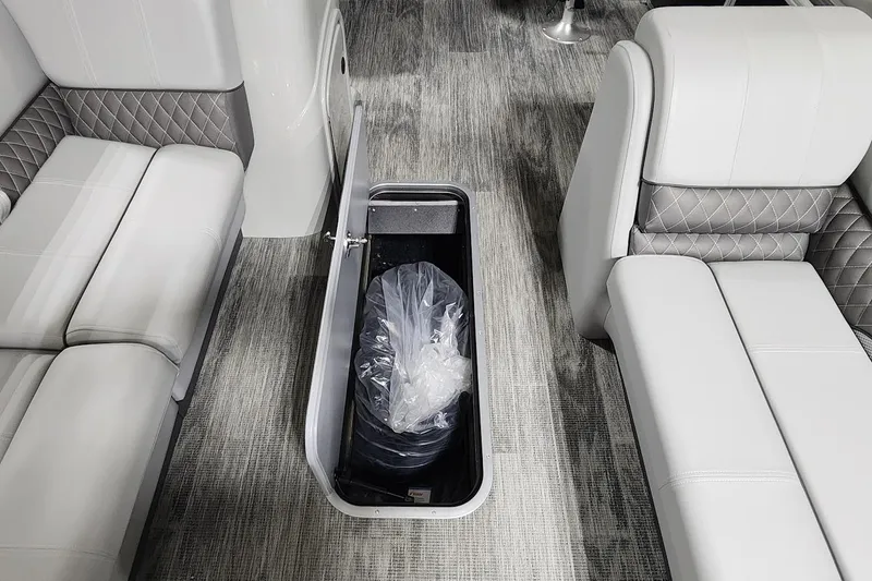 Slide: The Image of 2025 Ranger Reata 243C interior with open storage compartment and luxurious seating. - 8