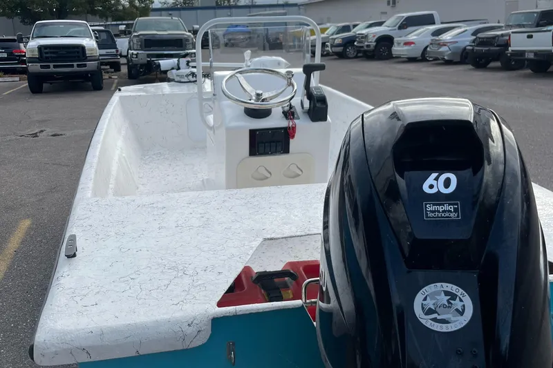 Slide: The Image of 2025 Rabco 16' Buccaneer boat with 60 HP engine in parking lot. - 2