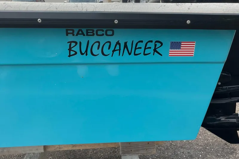 Slide: The Image of 2025 Rabco 16' Buccaneer boat with American flag decal on blue hull. - 3