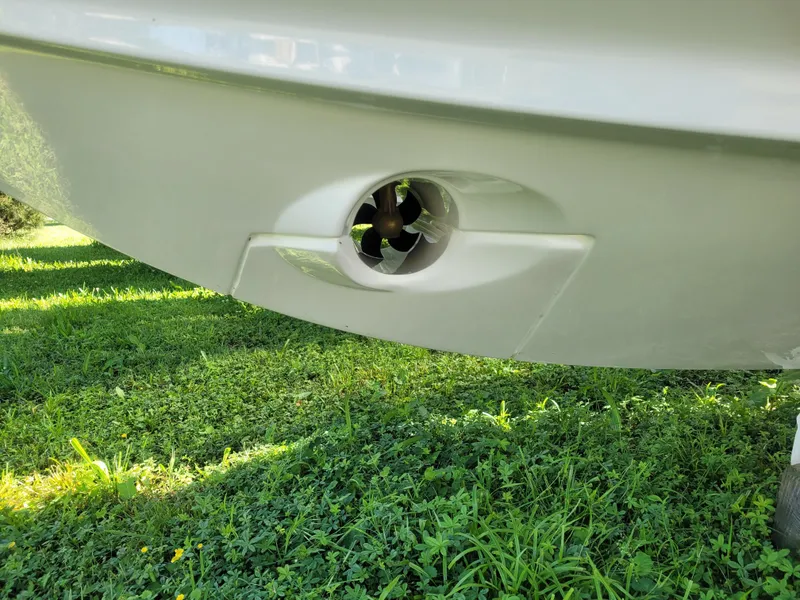 Slide: The Image of 2025 Bayliner Trophy T23 Explorer hull detail with thruster, on grassy surface. - 3