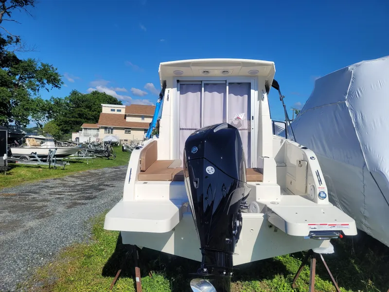 Slide: The Image of 2025 Bayliner Trophy T23 Explorer boat with outboard motor, parked outdoors. - 5