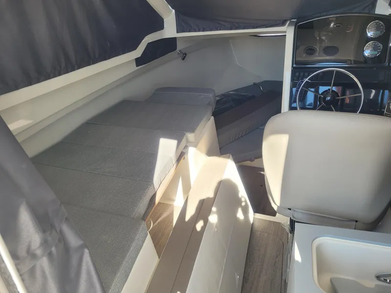 Slide: The Image of Interior of 2025 Bayliner Trophy T23 Explorer boat, featuring seating and steering area. - 7