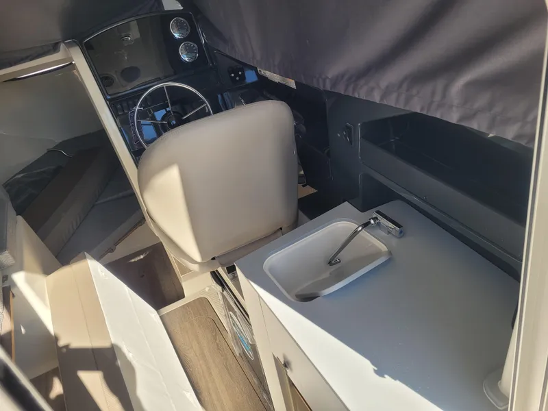 Slide: The Image of Interior of 2025 Bayliner Trophy T23 Explorer with helm and compact sink area. - 8