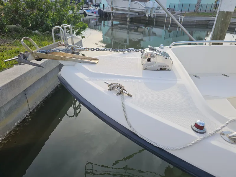 Slide: The Image of 1994 Pursuit 2150 DC boat bow with anchor and rope in a marina setting. - 4