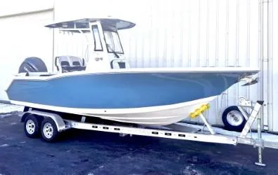 Slide: The Image of 2025 Tidewater 232 LXF boat on trailer, blue hull, parked outdoors. - 1