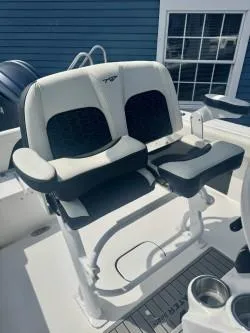 Slide: The Image of 2025 Tidewater 232 LXF boat seating with dual cup holders, white and black upholstery. - 12