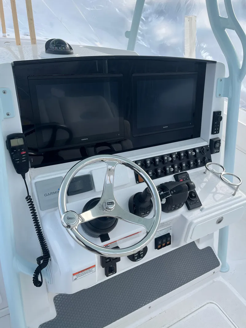 Slide: The Image of 2017 Southport 33 LX boat dashboard with dual screens and steering wheel. - 15