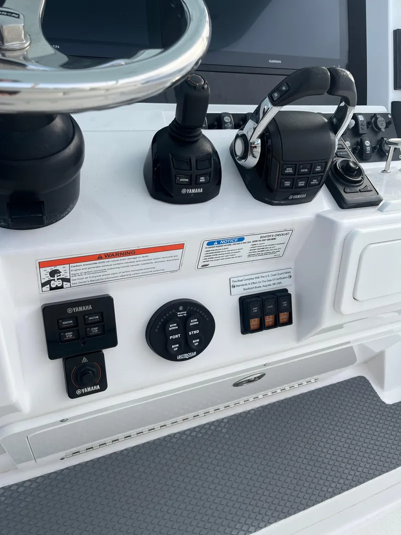 Slide: The Image of Control panel of a 2017 Southport 33 LX boat with steering and navigation controls. - 17