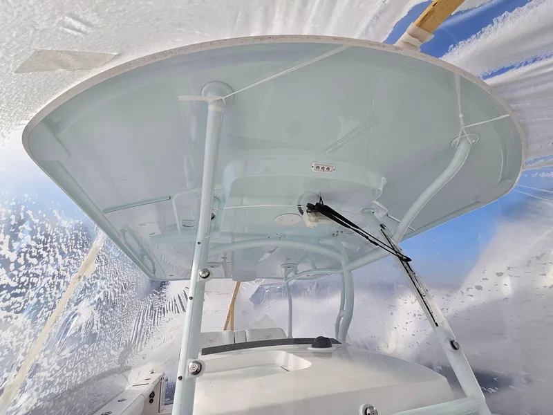 Slide: The Image of 2017 Southport 33 LX boat under protective cover, showcasing its T-top structure. - 19