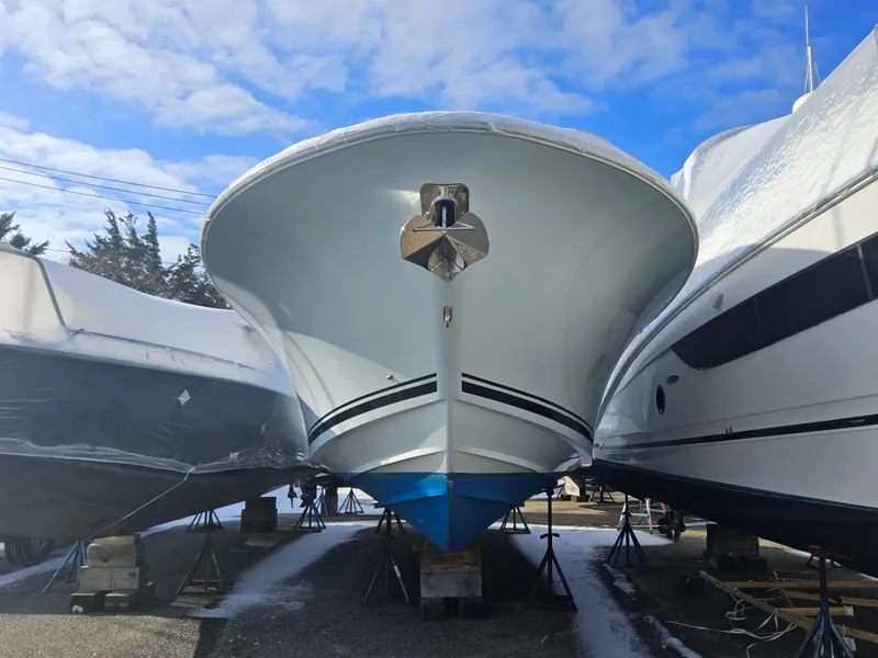 Slide: The Image of 2017 Southport 33 LX boat in storage, flanked by other vessels, under a clear blue sky. - 2