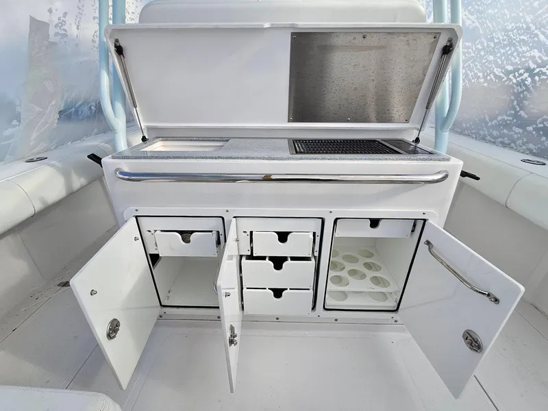 Slide: The Image of 2017 Southport 33 LX boat interior with open storage compartments and drawers. - 8