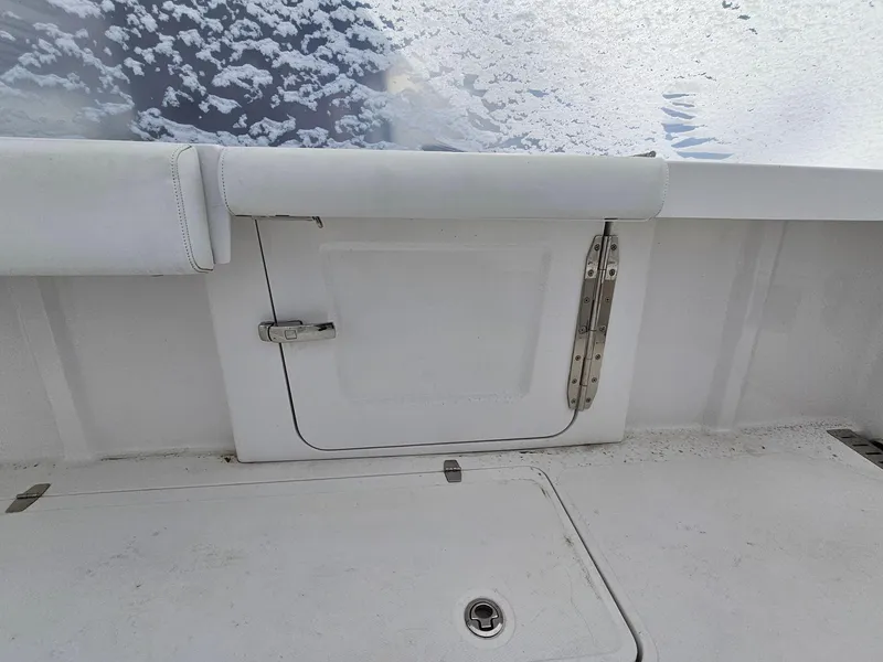 Slide: The Image of 2017 Southport 33 LX boat interior with white seating and storage compartment. - 9