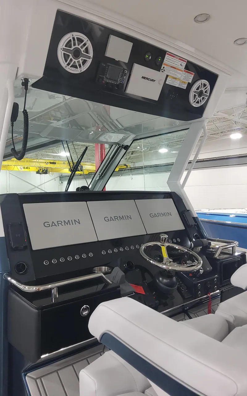 Slide: The Image of 2025 Formula 387 Center Console Fish boat dashboard with Garmin displays and steering wheel. - 14
