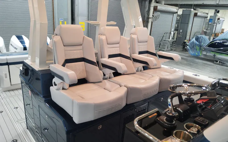 Slide: The Image of 2025 Formula 387 Center Console Fish boat interior with three luxury seats and control panel. - 20