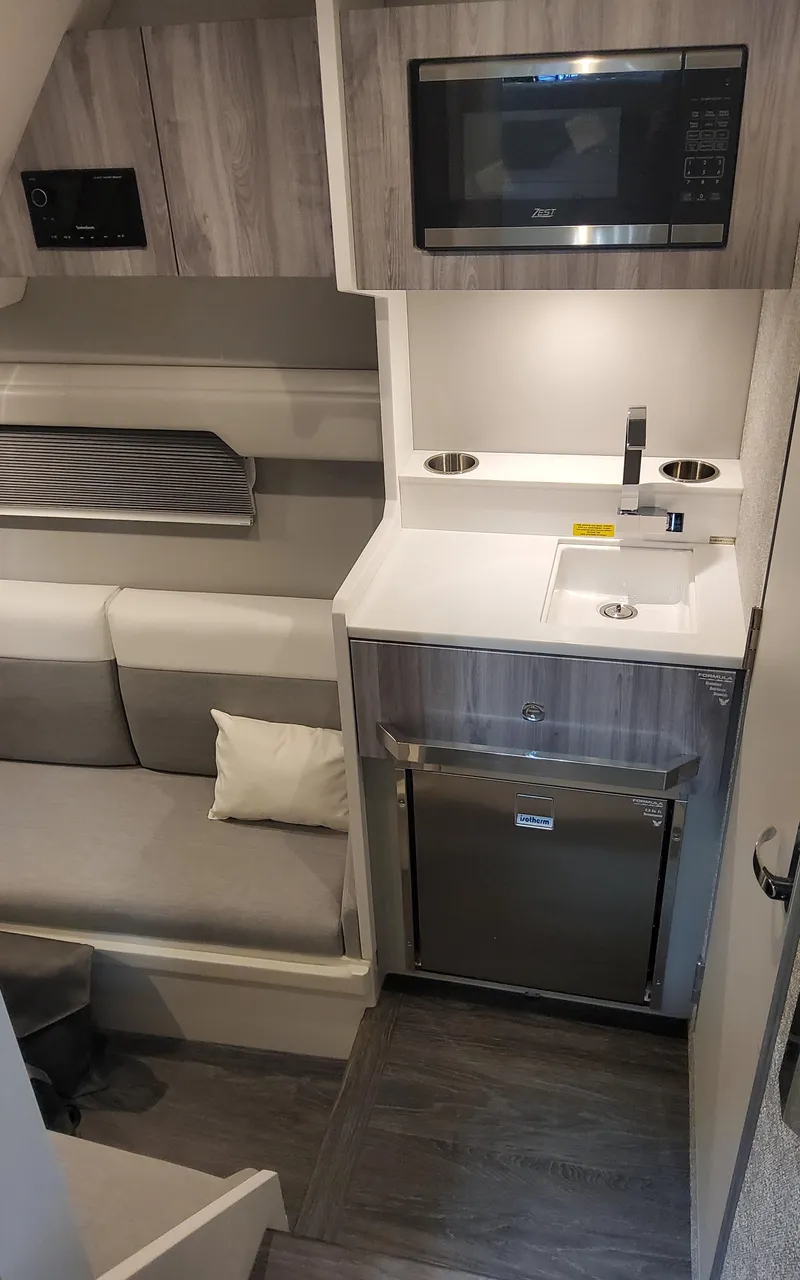 Slide: The Image of 2025 Formula 387 Center Console Fish interior with kitchenette and seating area. - 34