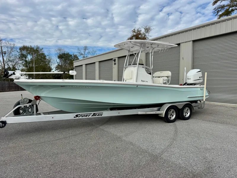 Slide: The Image of 2020 BlackJack 256 Bay boat on trailer, parked outside storage facility. - 1
