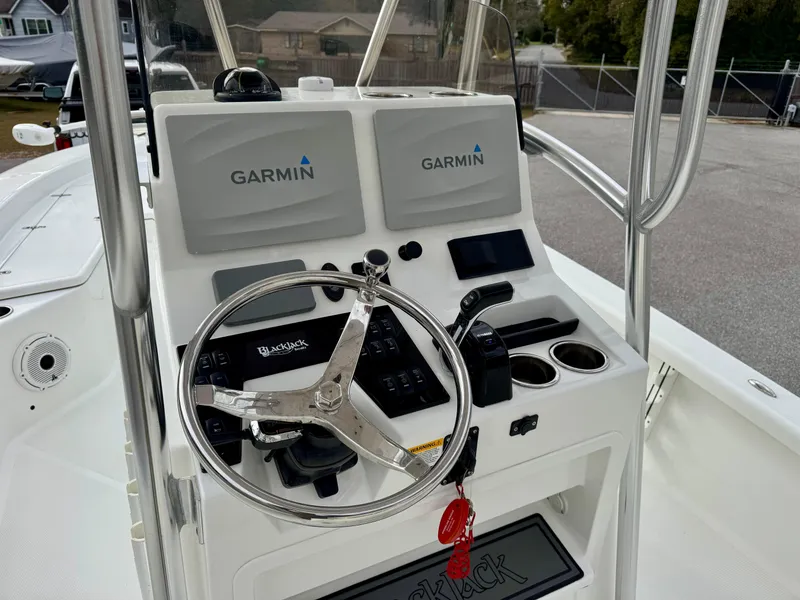 Slide: The Image of 2020 BlackJack 256 Bay boat console with Garmin navigation systems and steering wheel. - 13