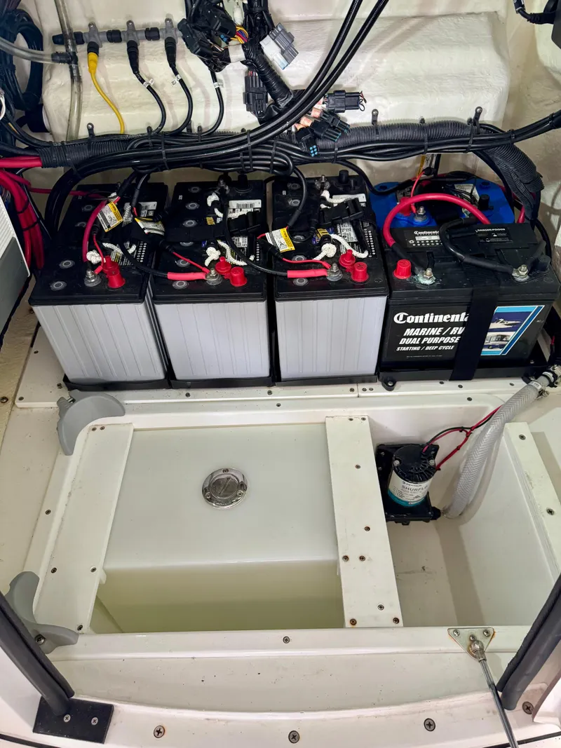 Slide: The Image of 2020 BlackJack 256 Bay boat battery compartment with multiple batteries and wiring. - 17