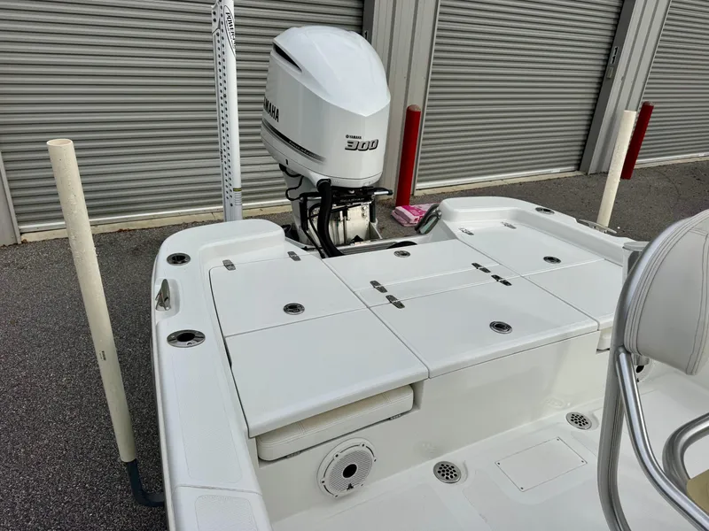 Slide: The Image of 2020 BlackJack 256 Bay boat with Yamaha 300 outboard motor, docked near storage units. - 9