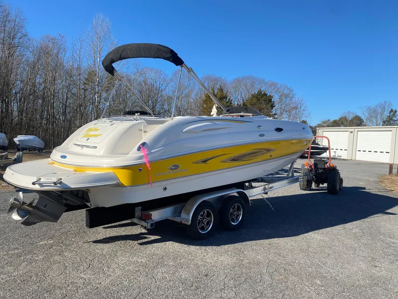 The Image of 2006 Chaparral Sunesta 252 boat on trailer, yellow and white, parked outdoors. - 0