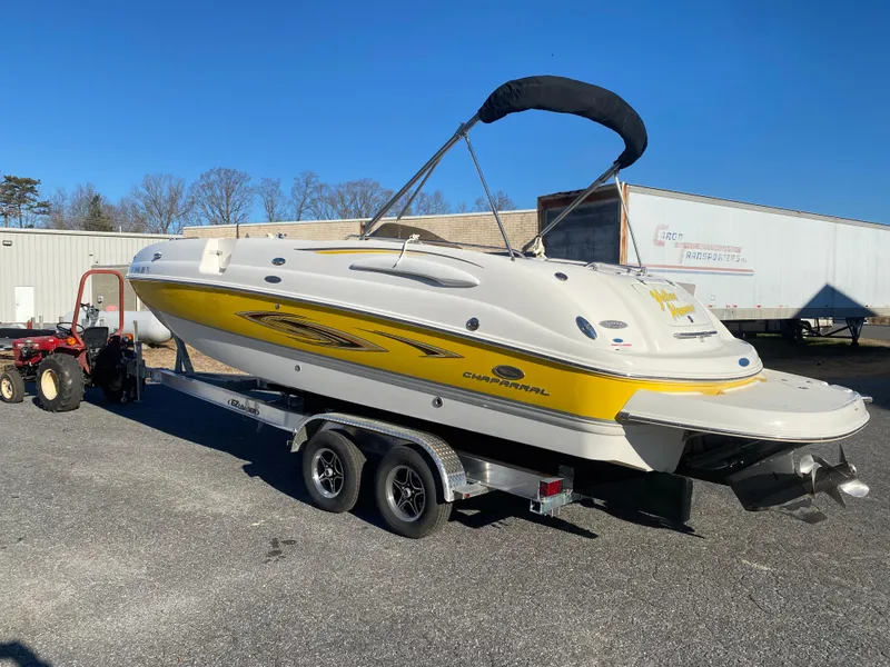 Slide: The Image of 2006 Chaparral Sunesta 252 boat on trailer, yellow and white design, parked outdoors. - 1