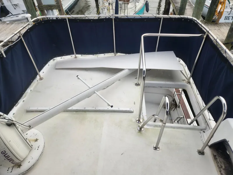 Slide: The Image of 1981 Mainship 34 Trawler deck with blue railing and ladder. - 19