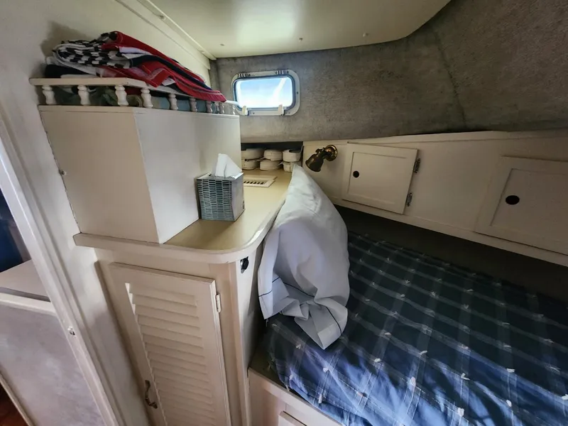 Slide: The Image of Cozy cabin interior of 1981 Mainship 34 Trawler with bed and storage. - 30