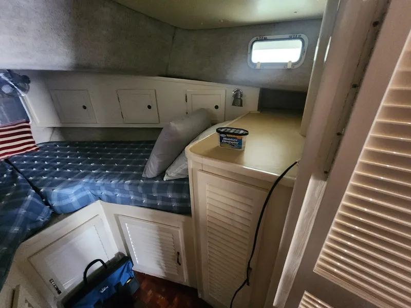 Slide: The Image of 1981 Mainship 34 Trawler cabin interior with bed, storage, and small window. - 31
