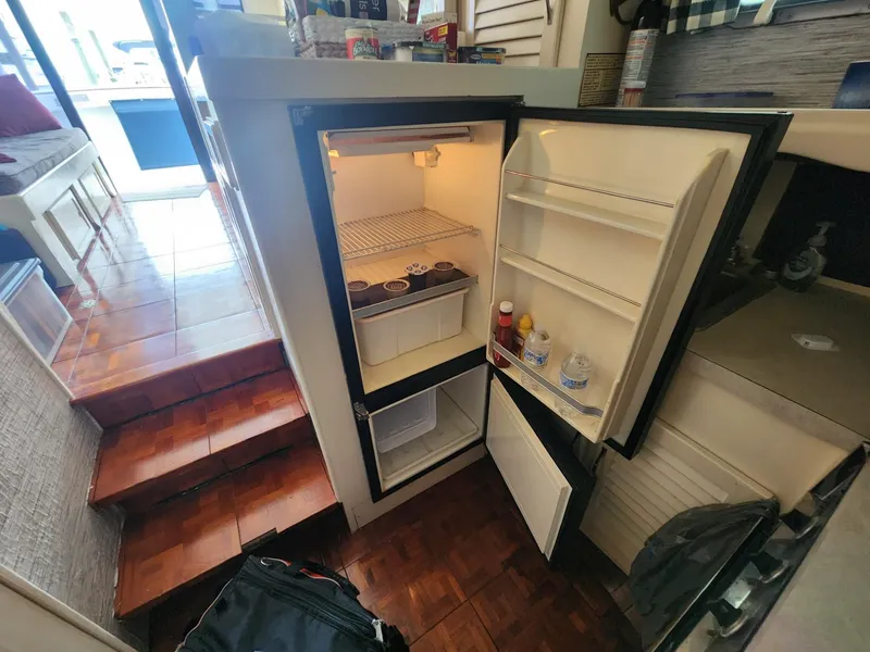 Slide: The Image of Open refrigerator inside 1981 Mainship 34 Trawler, showing interior shelves and contents. - 33