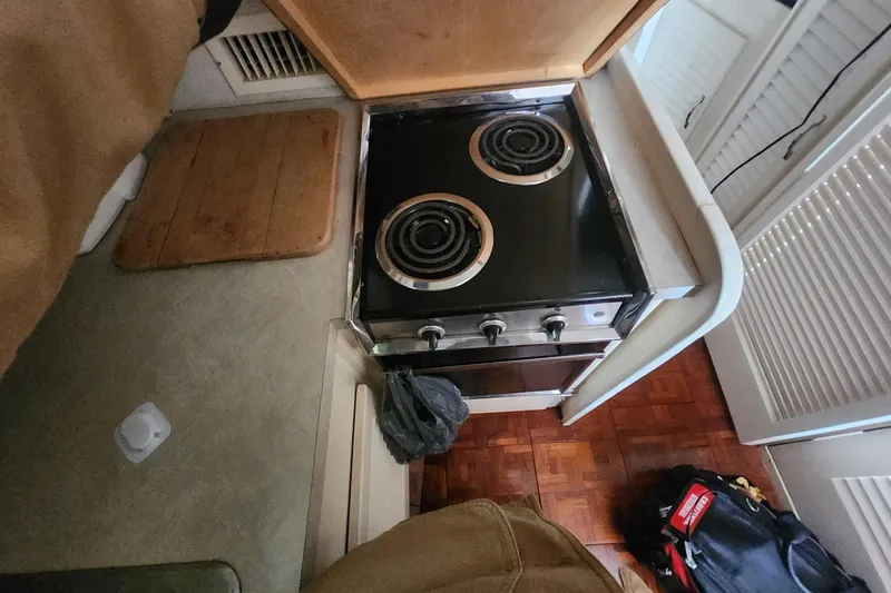 Slide: The Image of 1981 Mainship 34 Trawler kitchen with electric stove and wooden flooring. - 35