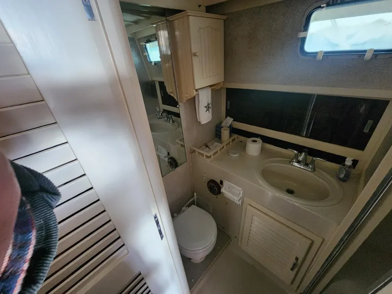 Slide: The Image of 1981 Mainship 34 Trawler bathroom with sink, toilet, and window. - 36