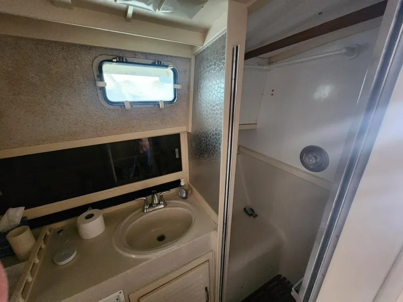 Slide: The Image of 1981 Mainship 34 Trawler bathroom with sink, mirror, and shower area. - 37