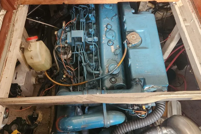 Slide: The Image of Engine compartment of a 1981 Mainship 34 Trawler, showcasing a blue marine engine. - 38
