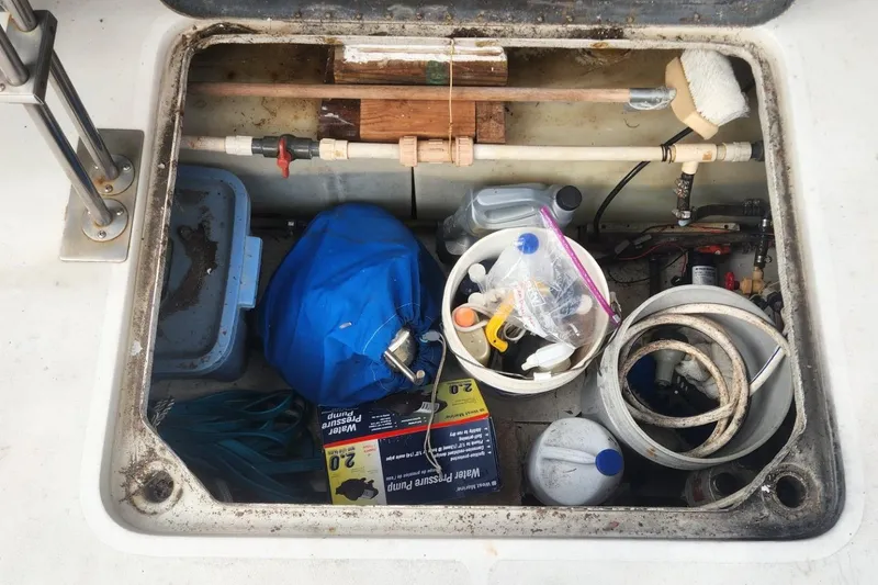Slide: The Image of Storage compartment on a 1981 Mainship 34 Trawler with various tools and supplies. - 43