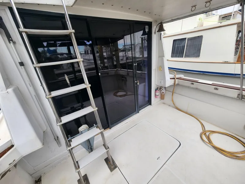 Slide: The Image of 1981 Mainship 34 Trawler deck with ladder and sliding glass doors. - 6