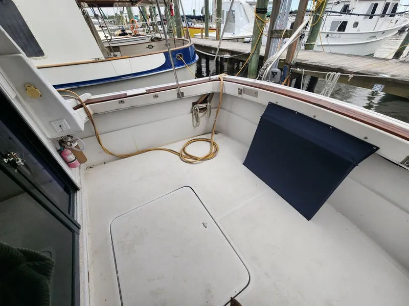 Slide: The Image of 1981 Mainship 34 Trawler deck, docked with visible ropes and equipment. - 7